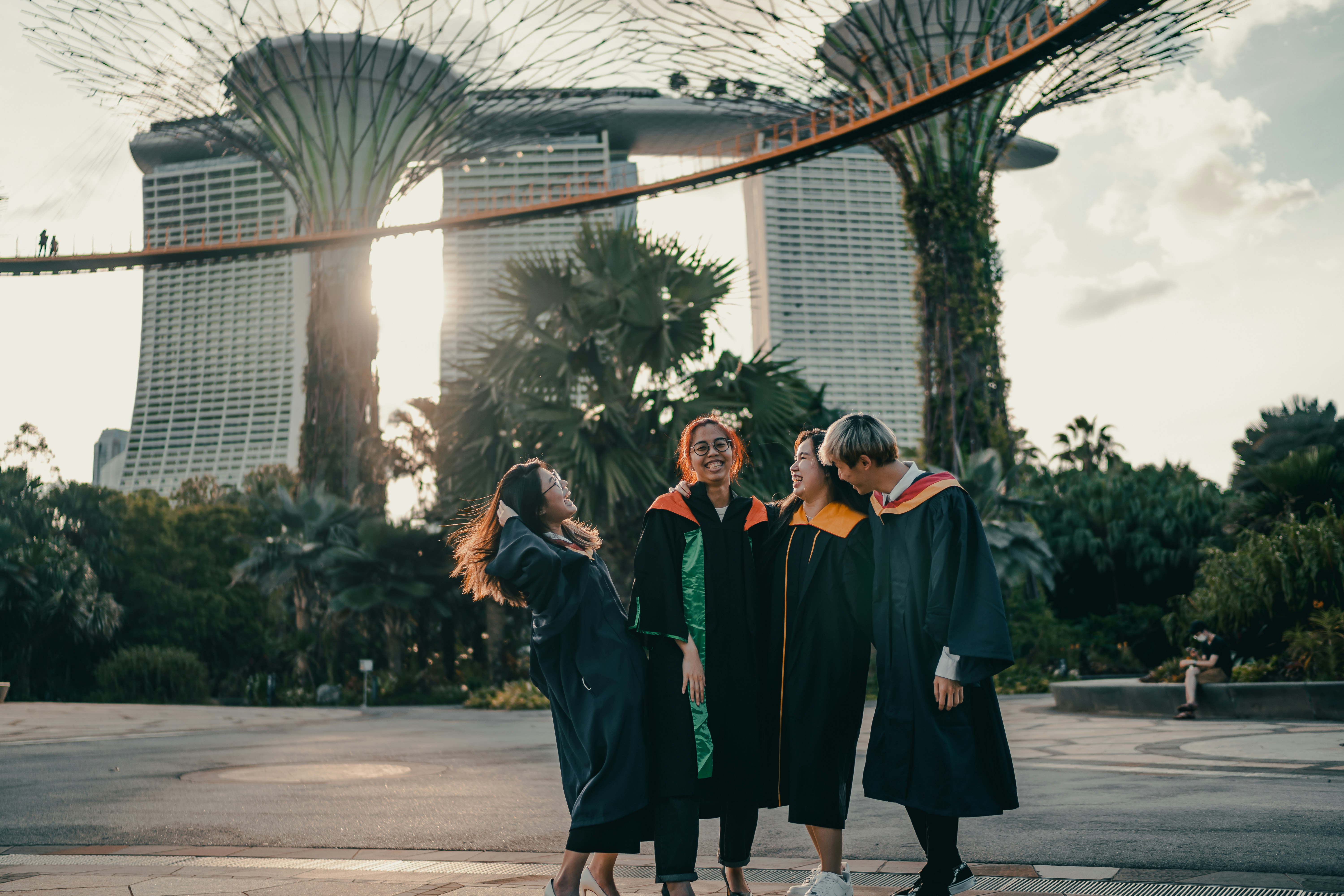 woman in black academic dress standing on gray concrete floor during daytime